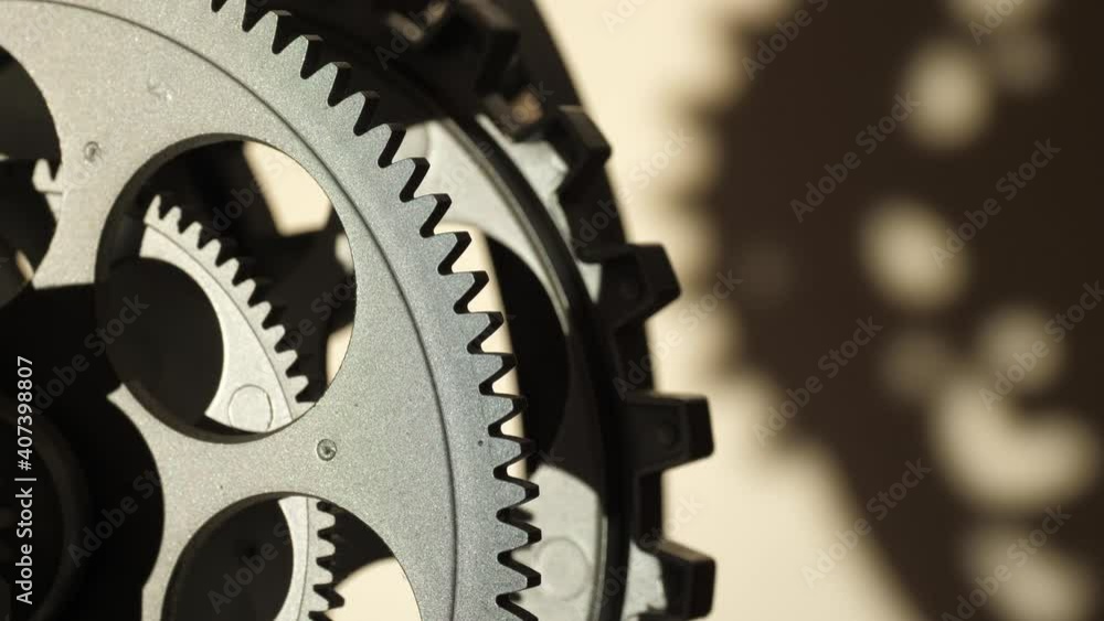Close up cogwheels of an industrial looking clock shadows Close up cogwheels of an industrial looking clock shadows