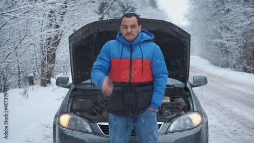 Angry man calls on the phone near the broken car