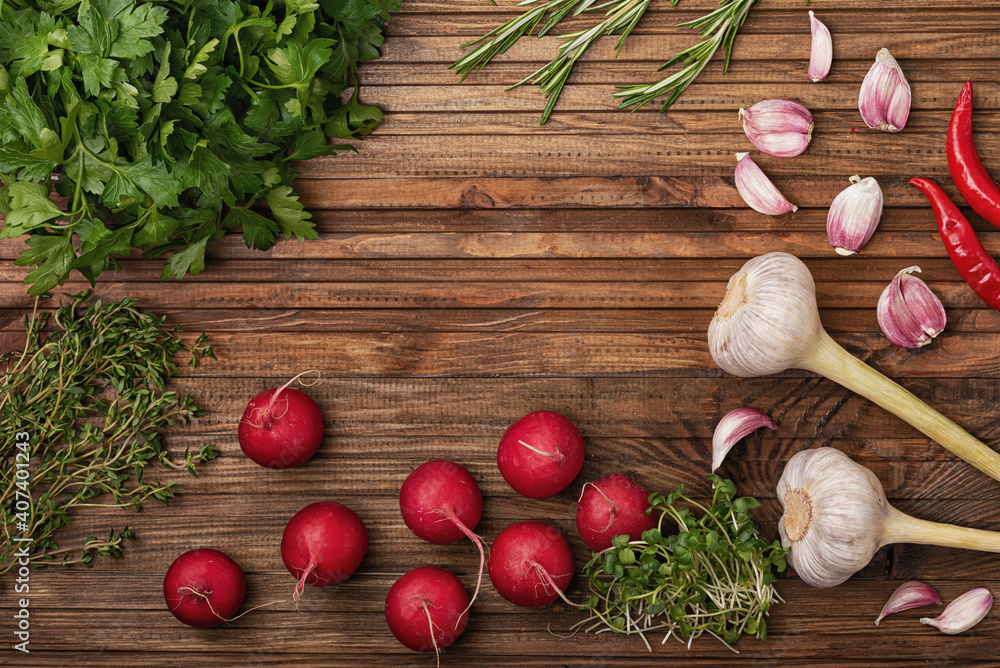 
Radish, garlic, parsley rosemary and micro green are laid out on a wooden kitchen table