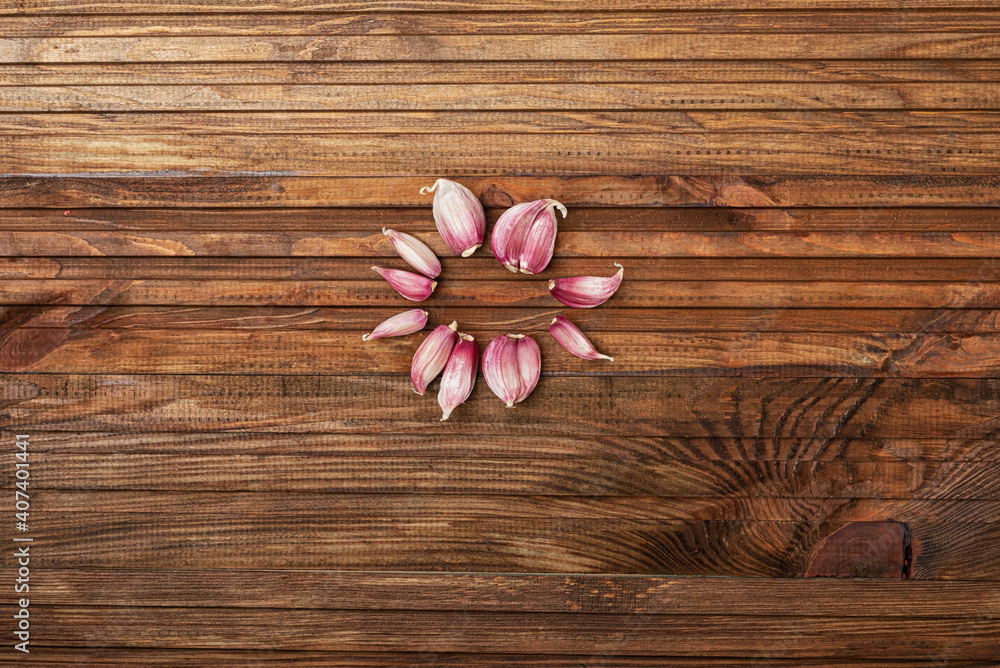 Fresh garlic laid out in a circle in the center of a wooden kitchen table