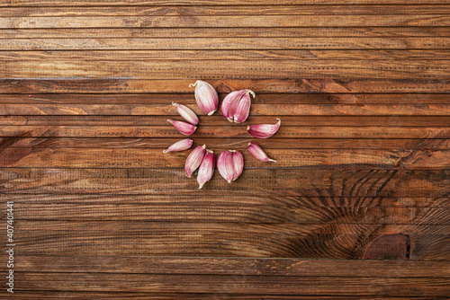 Fresh garlic laid out in a circle in the center of a wooden kitchen table