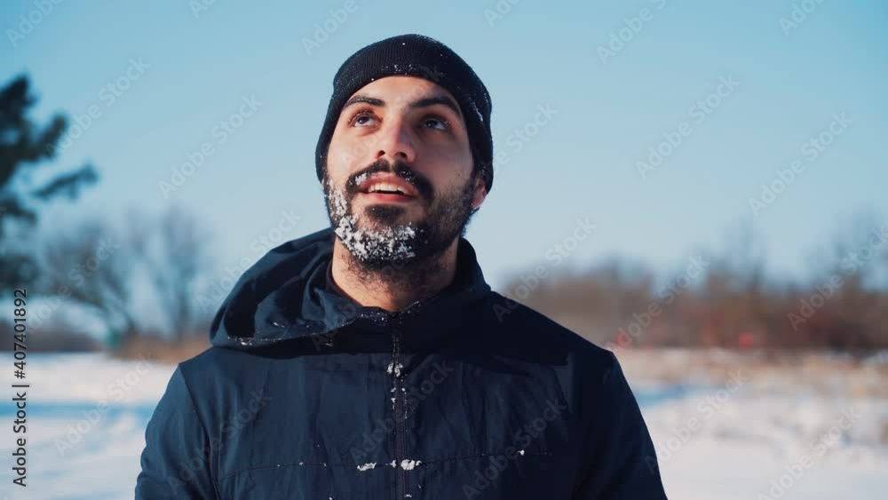 Portrait of a Happy Man with a Beard in a Winter Hat Covered in Snow Smiling and looking at the camera. Positive emotions and good mood. Slow motion. High quality FullHD footage Portrait of a Happy Man with a Beard in a Winter Hat Covered in Snow Smiling and looking at the camera. Positive emotions and good mood. Slow motion. High quality FullHD footage
