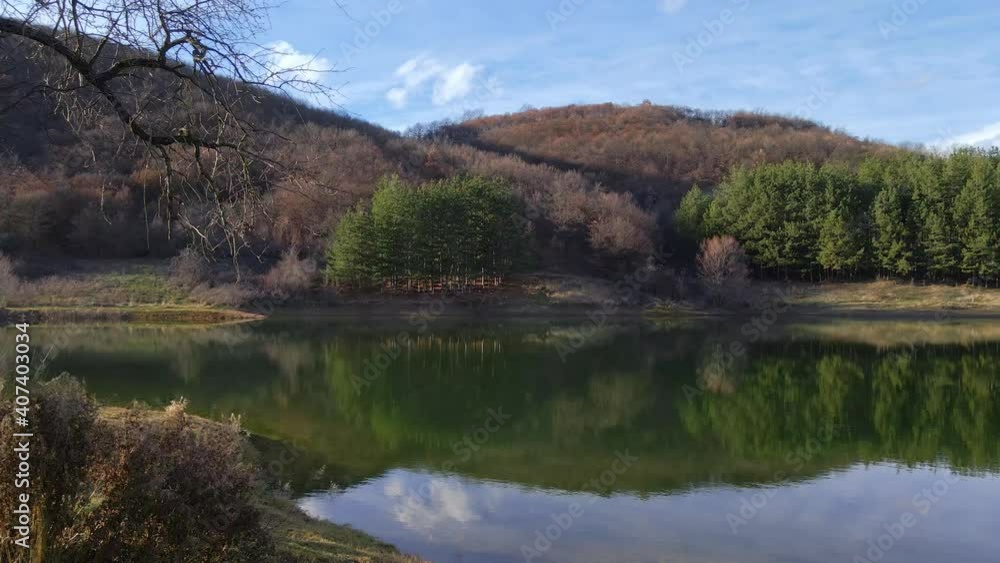 Rotating panoramic lake view with a small white Christian chapel. Beautiful reflection in the mountain lake. The little house and the blue sky with clouds. A place for relaxation and rest. Rotating panoramic lake view with a small white Christian chapel. Beautiful reflection in the mountain lake. The little house and the blue sky with clouds. A place for relaxation and rest.