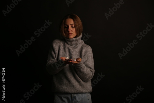 Young woman with candles in her hands on black background photo