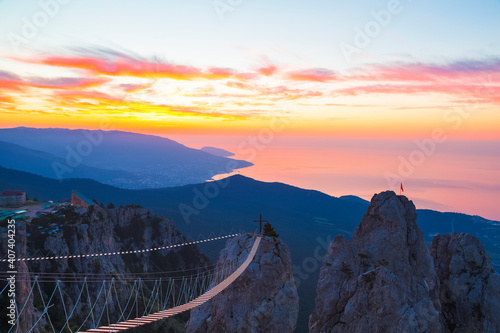 Tableau sur toile View from the top of Ai-Petri Mountain to the surrounding mountains, the Black Sea and the city of Yalta on the horizon at dawn