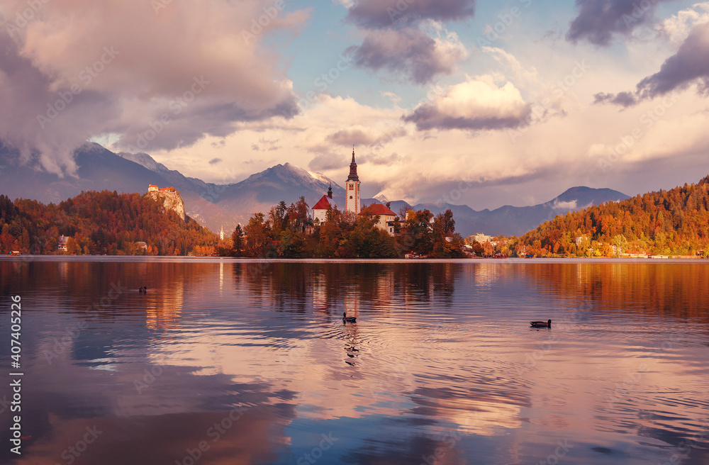 Scenic image of Fairytale lake Bled during pinc sunset. Natural summer scenery with colorful sky. Fantastic Picturesque Scene over famouse lake. Julian Alps. Slovenia. Wonderful Autumn landscape.