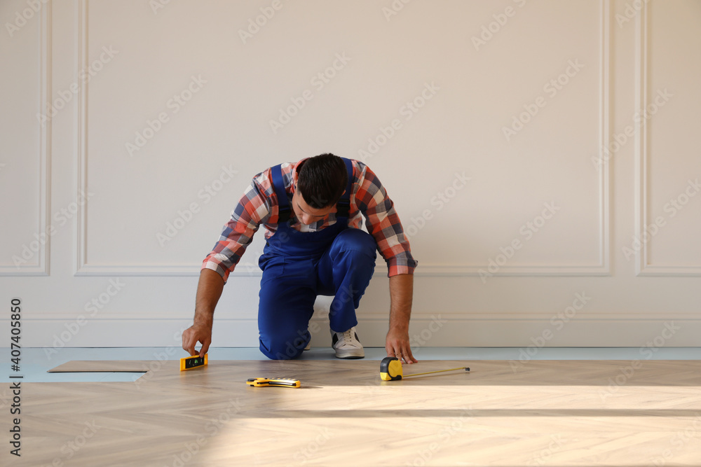 Professional worker installing new parquet flooring indoors - obrazy, fototapety, plakaty 