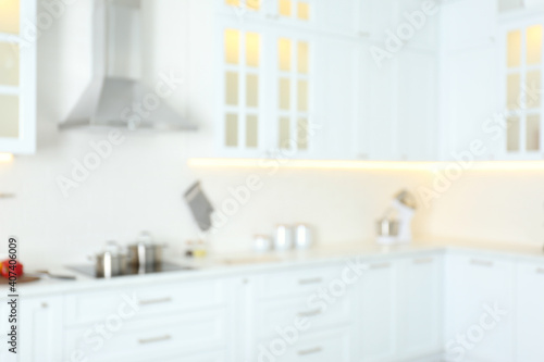 Blurred view of modern kitchen interior with white furniture