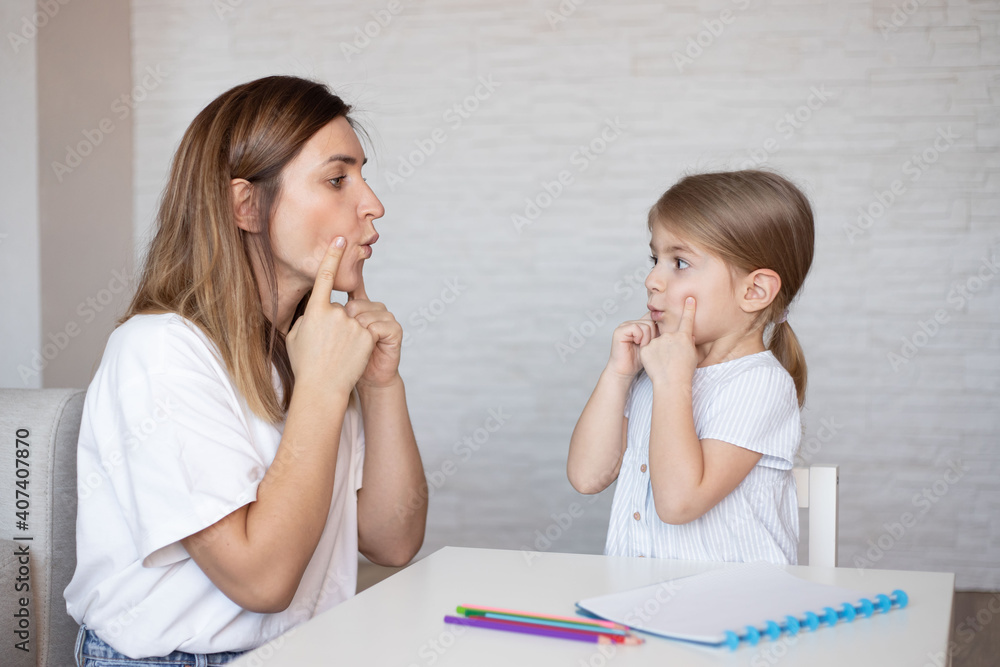 Cute little girl with speech therapist.Young woman teacher and child on private lesson. Cute little girl with speech therapist.Young woman teacher and child on private lesson.