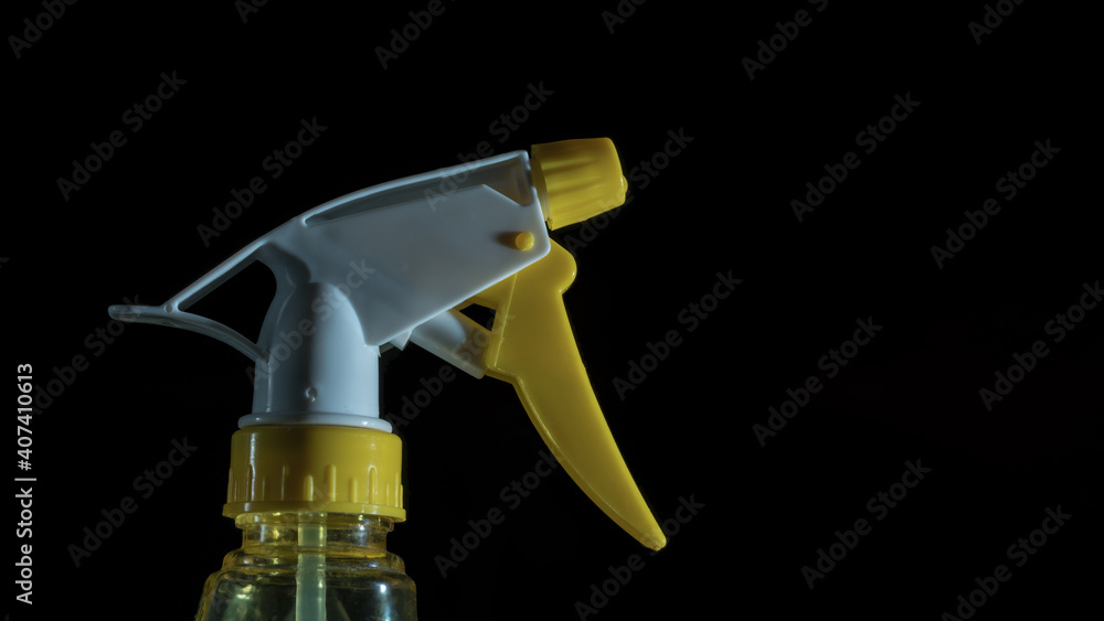 White and yellow sprayer bottle isolated on black background closeup. White and yellow sprayer bottle isolated on black background closeup.