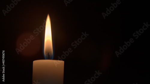 Candle flame isolated on black background in dark room close view.