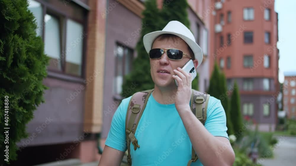 Man tourist talking on a mobile phone walking around the city, tracking cameras Man tourist talking on a mobile phone walking around the city, tracking cameras