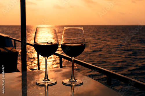 Obraz na plátně Glasses, red wine and tropical sunset with sea background, nobody
