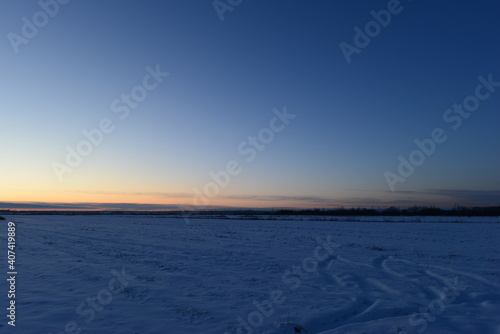 Winter dusky blue sky in a rural area over snowy fields