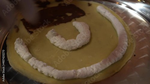 Chef making chocolate nutella spearding with cream on crepe photo