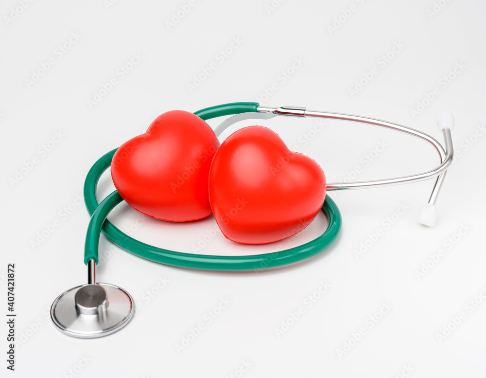 medical stethoscope and red rubber heart on white background