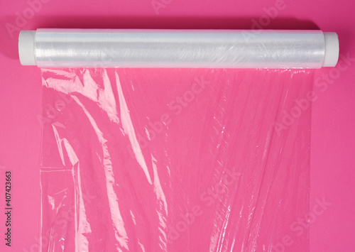 roll of transparent cling film on pink background