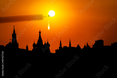 Abstract background. The concept of fire protection. A candle lit by the sun drips on the silhouette of the Moscow Kremlin and St. Basil's Cathedral