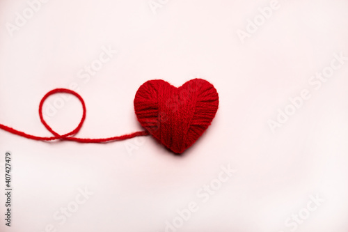 Red heart made of wool on a white background