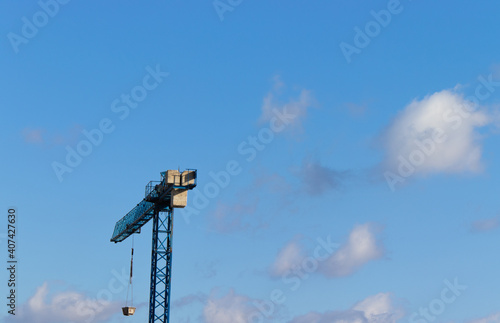 A green crane in contrast with the blue sky
