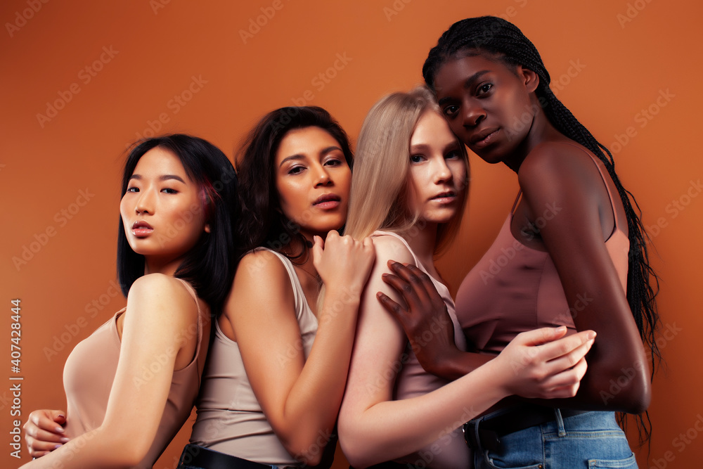 Obraz premium young pretty asian, caucasian, afro woman posing cheerful together on brown background, lifestyle diverse nationality people concept