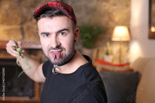Fotografi Man with forked tongue holding snakes
