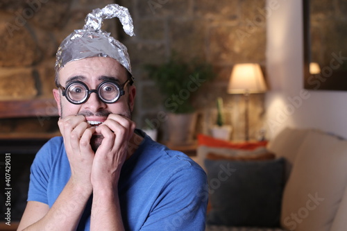 Paranoid man wearing weird tinfoil hat  photo