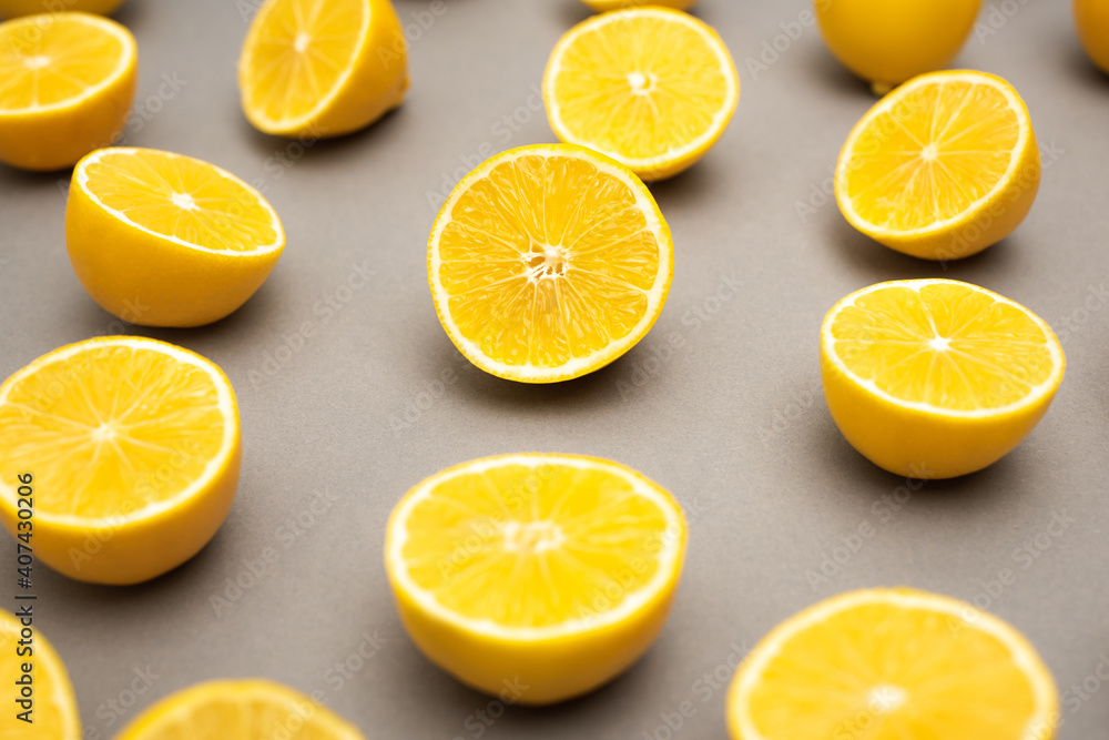 row of fresh and ripe lemons halves on grey