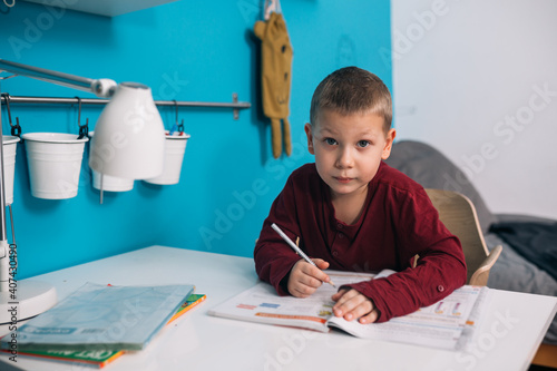 young boy doing homework in his room