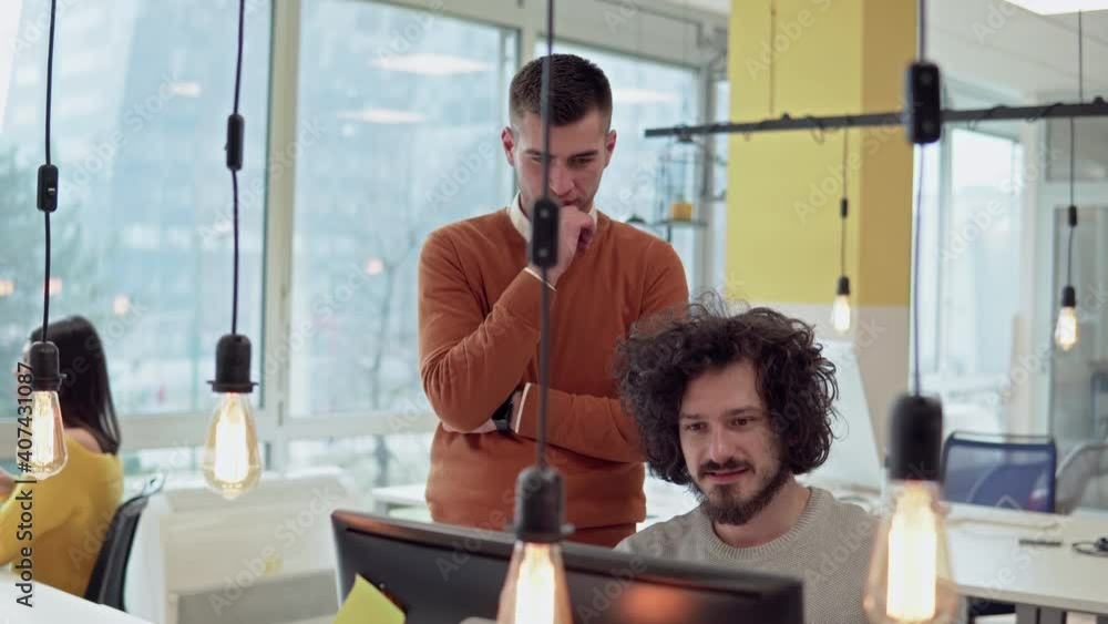 Hispanic designer with collage co-workers discuss new web page design in coworking startup office