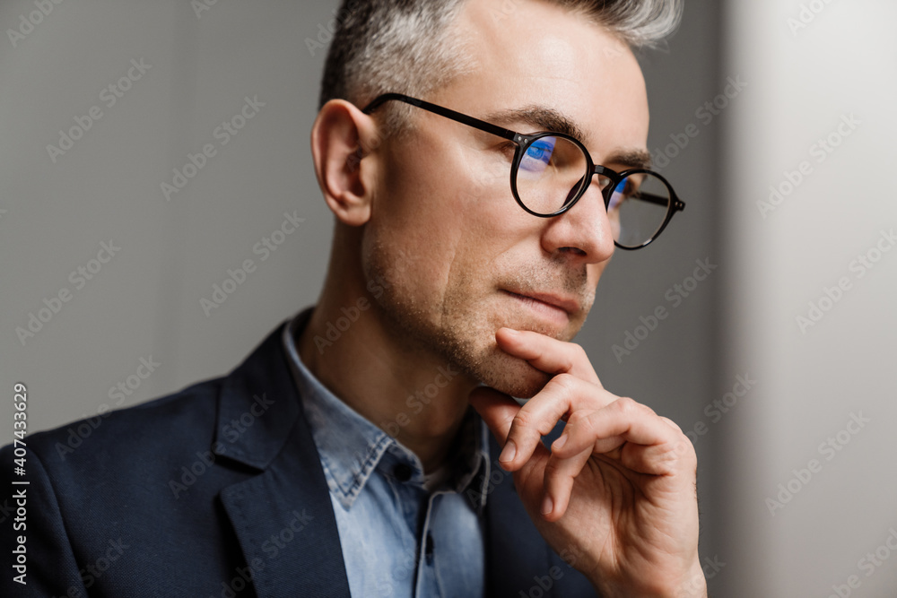 Serious grey man wearing eyeglasses thinking and looking forward Serious grey man wearing eyeglasses thinking and looking forward