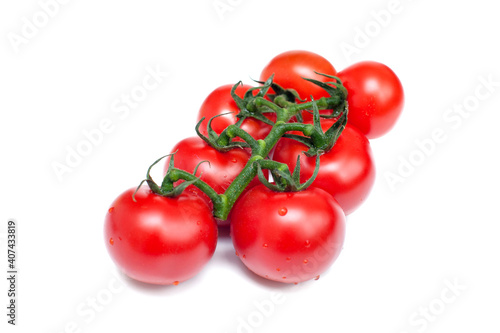 Bunch of fresh red tomatoes with green stems on a white background.