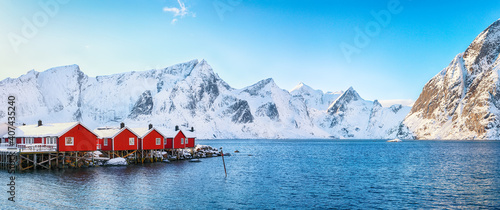 Traditional Norwegian red wooden houses (rorbuer) on the shore of  Reinefjorden near Hamnoy village