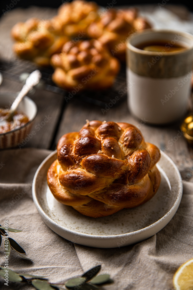 Breakfast with knot buns, orange jam and black tea with lemon on wooden table. Breakfast with knot buns, orange jam and black tea with lemon on wooden table.