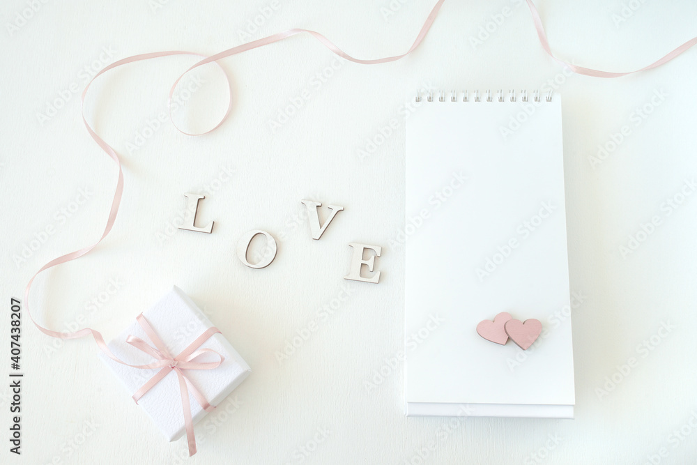 On a gentle light background gift box, notebook with free space and hearts, word love. Flat lay, top view. Lovely romantic background, great for Valentine's Day, Mother's Day, wallpapers. On a gentle light background gift box, notebook with free space and hearts, word love. Flat lay, top view. Lovely romantic background, great for Valentine's Day, Mother's Day, wallpapers.