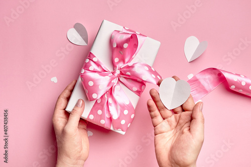 Gift box with big bow on pink background