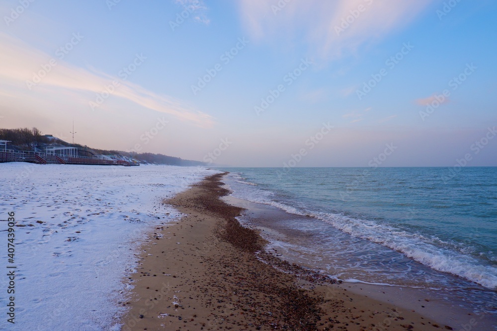 Baltic Sea coast in winter. Blue water, blue sky and snow on the shore.