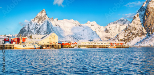 Fantastic winter view on Hamnoy village with port and Olstinden peak on background.