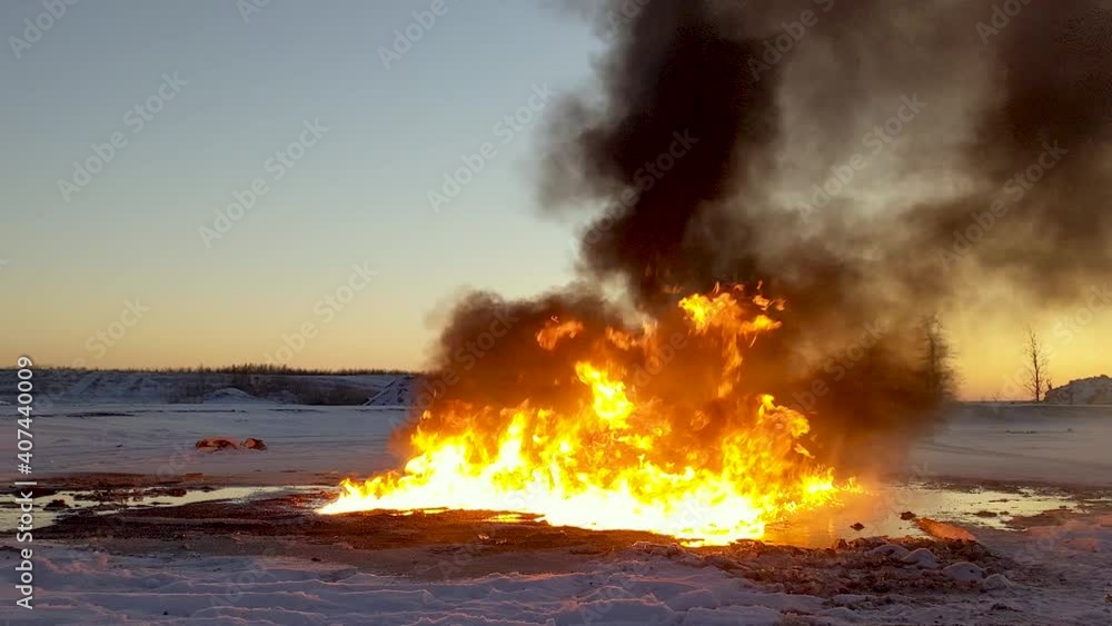 Huge dangerous raging fire burns rapidly sending thick black flames into the sky. Oil spill clean up procedure. Huge dangerous raging fire burns rapidly sending thick black flames into the sky. Oil spill clean up procedure.