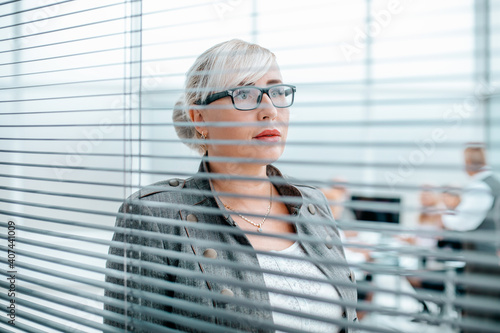 Obraz na płótnie close up. serious business woman looking through office window w salonie