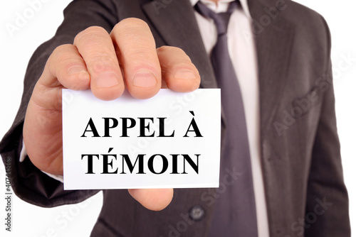 Homme tenant une carte sur laquelle est écrit appel à témoin photo