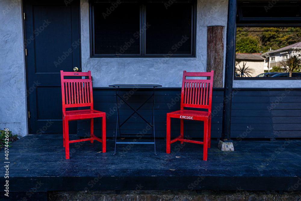 Two red Chairs are placed in front of coffee shop. 