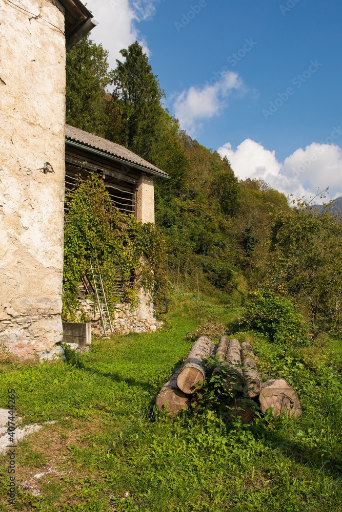 Fototapeta premium The autumn landscape near Zadlaz-Cadrg and Zatolmin in the Tolmin district of the Slovenian Littoral or Primorska region of western Slovenia. An old farm building for storing hay is on the left 