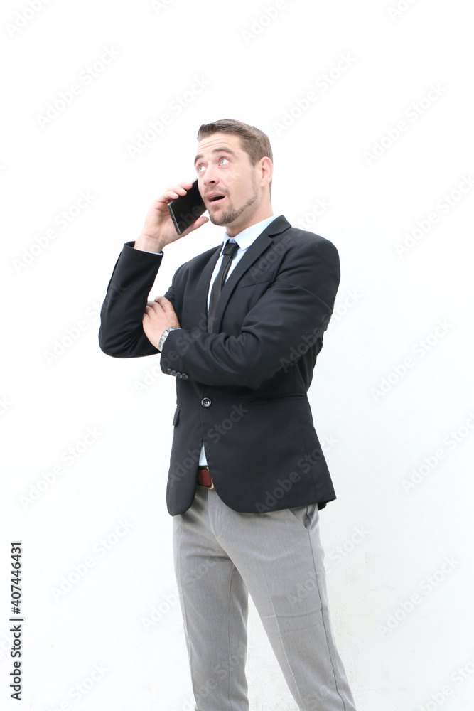 Handsome shocked businessman wearing suit standing over isolated white background and emotionally talking on the phone.Surprised office worker or boss over isolated background chatting Handsome shocked businessman wearing suit standing over isolated white background and emotionally talking on the phone.Surprised office worker or boss over isolated background chatting