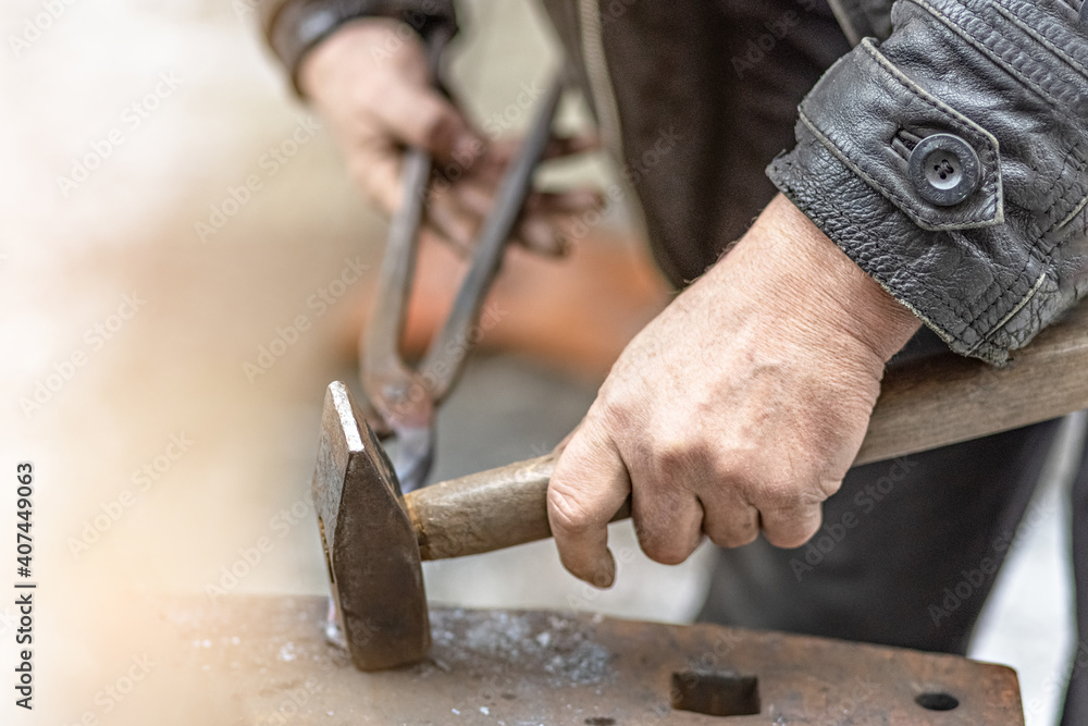 A blacksmith man forge a horseshoe on an anvil