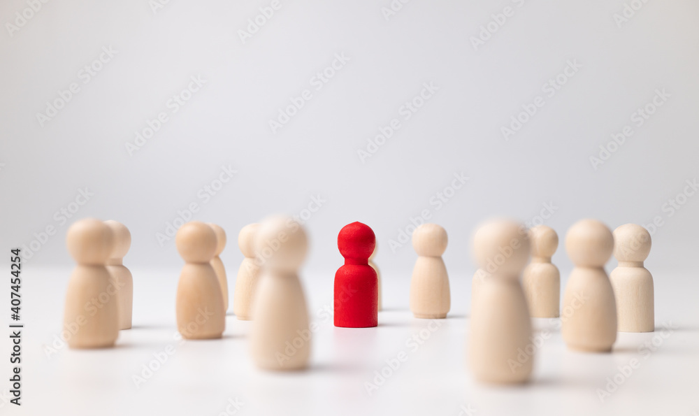 A wooden figure standing with a team to influence and empowerment. Concept of leadership, successful competition winner and Leader with influence and Social distancing for a new normal lifestyle A wooden figure standing with a team to influence and empowerment. Concept of leadership, successful competition winner and Leader with influence and Social distancing for a new normal lifestyle