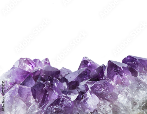 Close up view of large violet amethyst crystal cluster border isolated with white background. Esoteric magical background concept.