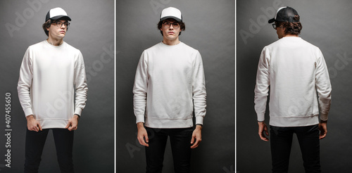 Man wearing blank white sweatshirt and empty baseball cap standing over gray background. Sweatshirt or hoodie for mock up, logo designs or design print with with free space.