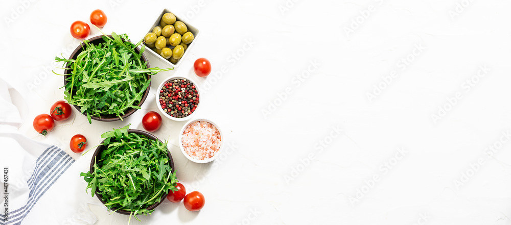 Fresh organic ingredients for spring juicy salad on white concrete background long banner format, copy space for your text.