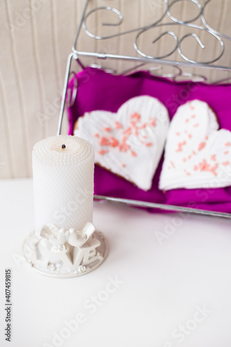 candle and biscuits in the form of heart on a pink napkin